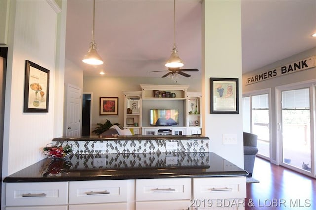 interior space with decorative light fixtures, backsplash, ceiling fan, and white cabinetry