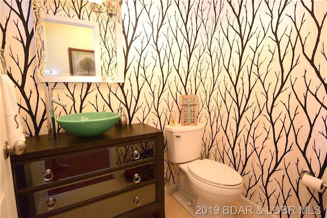 bathroom featuring vanity, tile flooring, and toilet