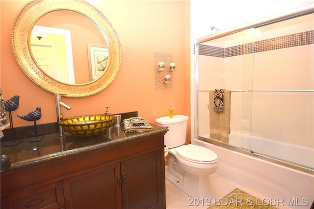 full bathroom featuring large vanity, toilet, enclosed tub / shower combo, and tile floors