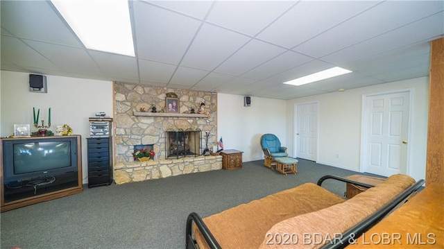 living room with carpet floors, a drop ceiling, and a fireplace