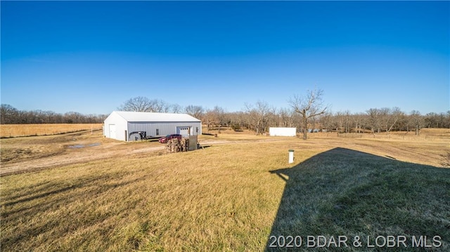 view of yard with a rural view and an outdoor structure