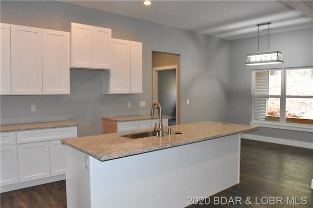 kitchen featuring decorative light fixtures, white cabinets, light stone counters, and dark hardwood / wood-style flooring