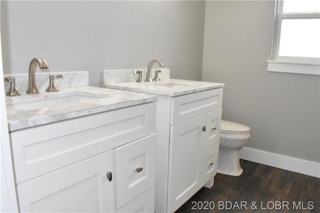 bathroom with toilet, hardwood / wood-style floors, and vanity