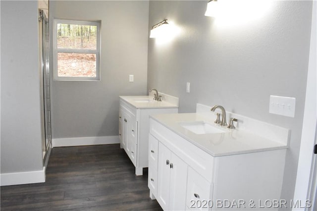 bathroom with wood-type flooring and double sink vanity