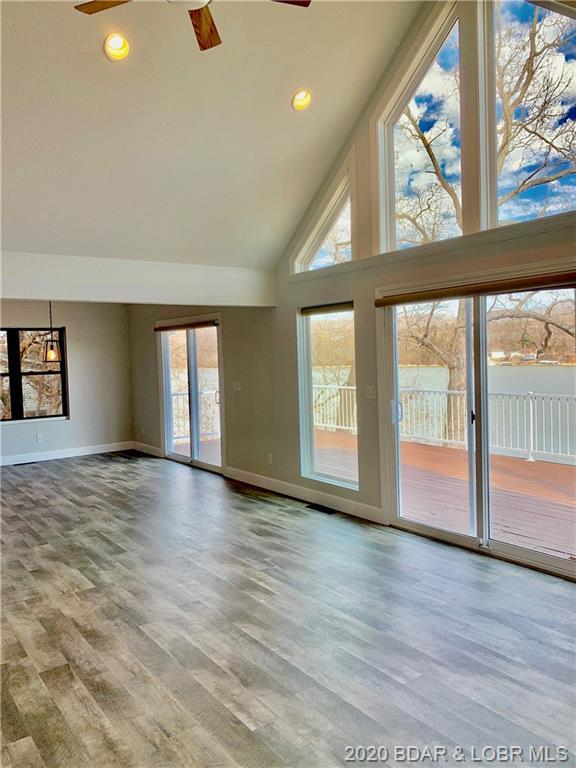 unfurnished living room with plenty of natural light, ceiling fan, and light wood-type flooring