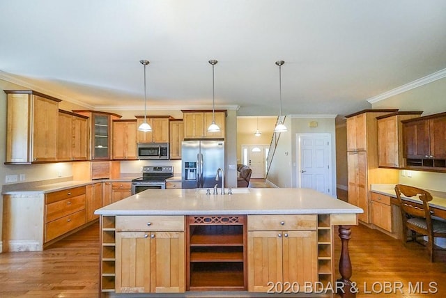 kitchen with an island with sink, stainless steel appliances, decorative light fixtures, and wood-type flooring