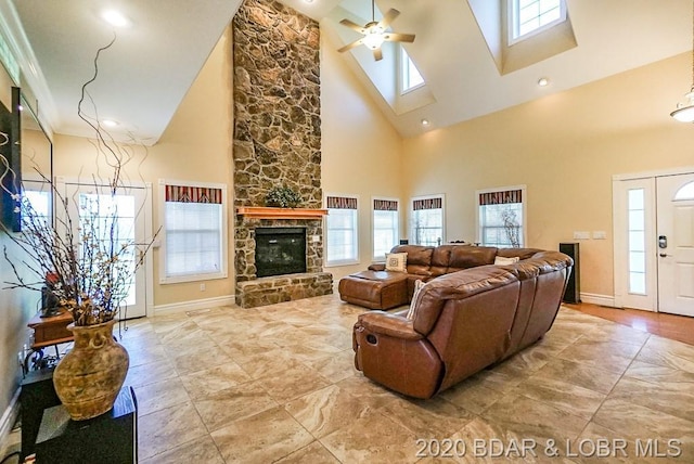 living room with plenty of natural light, ceiling fan, high vaulted ceiling, and a fireplace