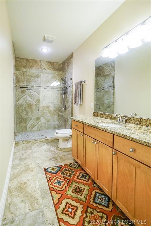 bathroom featuring toilet, tile flooring, an enclosed shower, and vanity