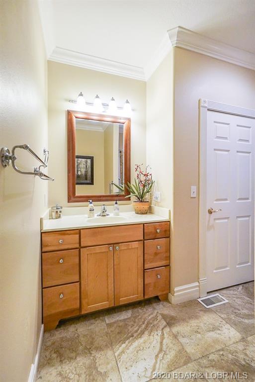 bathroom featuring ornamental molding, tile floors, and vanity