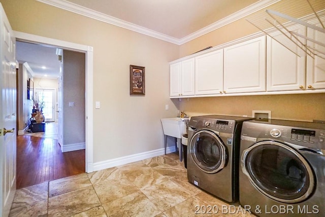 washroom featuring washing machine and clothes dryer, crown molding, light tile floors, hookup for a washing machine, and cabinets