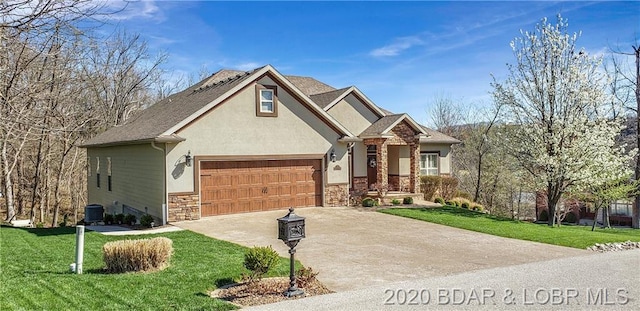 craftsman-style house featuring central air condition unit, a front lawn, and a garage