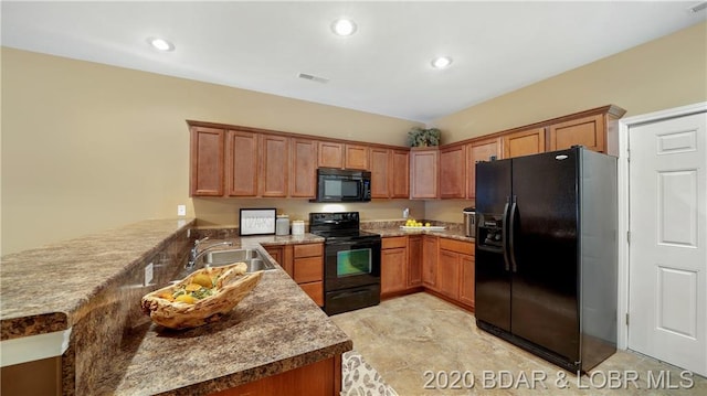 kitchen with dark stone countertops, light tile floors, sink, kitchen peninsula, and black appliances