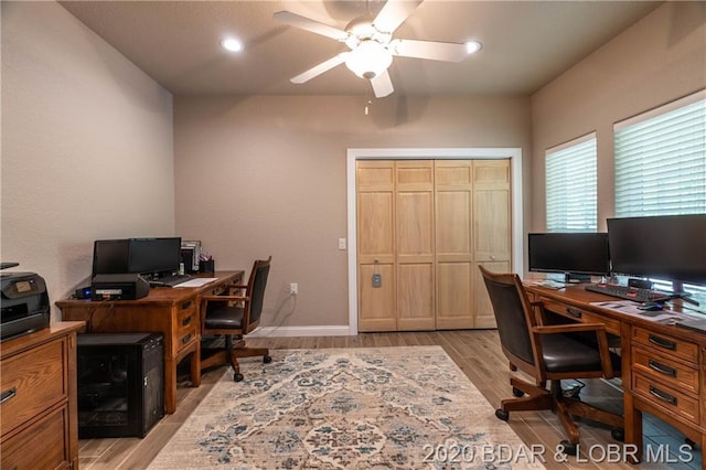 home office with ceiling fan and light hardwood / wood-style flooring