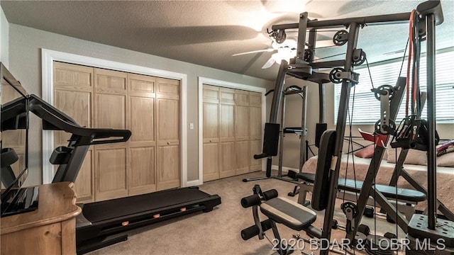 exercise area featuring light carpet, a textured ceiling, and ceiling fan