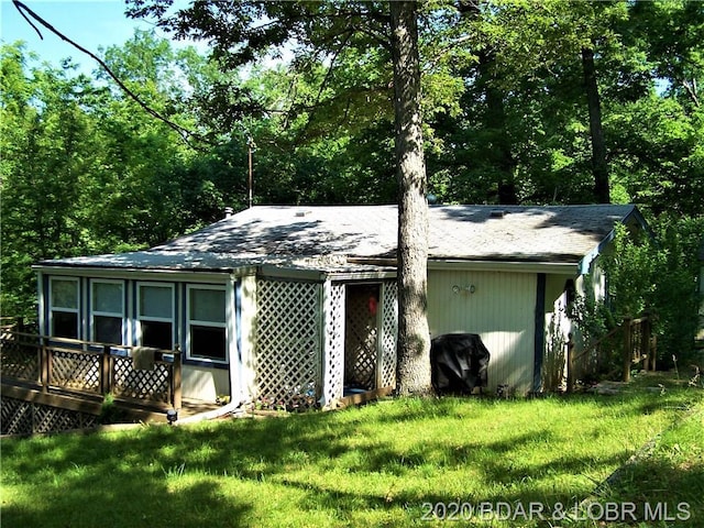 rear view of house featuring a yard and a wooden deck