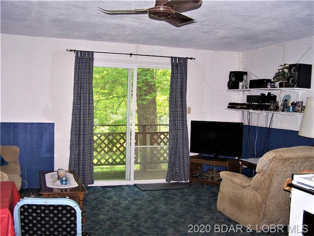 living room with carpet, ceiling fan, and a textured ceiling