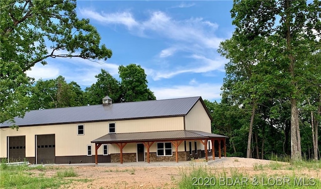 back of house featuring a porch and a garage