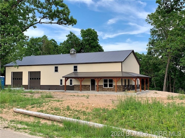 back of house featuring covered porch and a garage