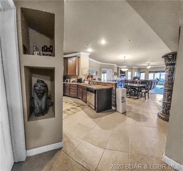 kitchen with stainless steel dishwasher, light tile floors, sink, and crown molding