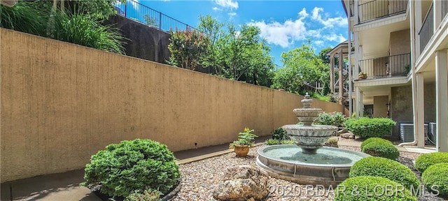 view of yard featuring a balcony and central AC