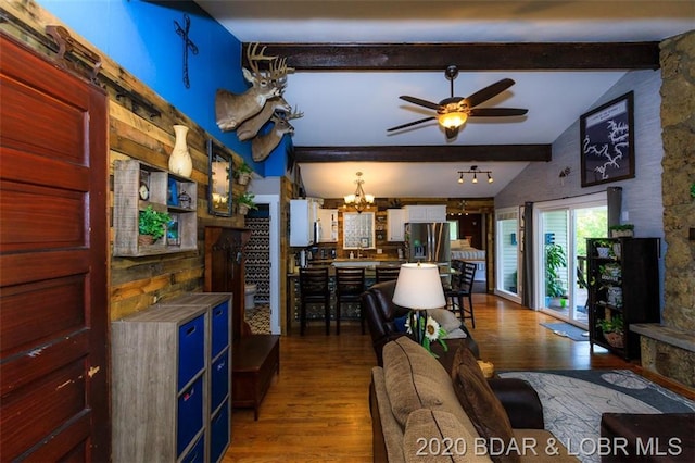 dining space featuring lofted ceiling with beams, sink, hardwood / wood-style floors, and ceiling fan with notable chandelier