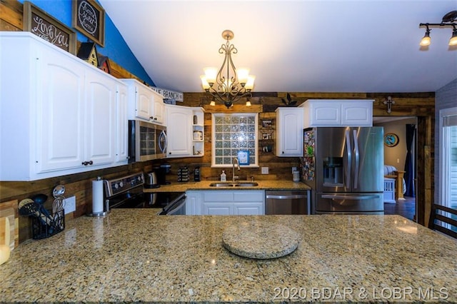 kitchen with decorative light fixtures, an inviting chandelier, appliances with stainless steel finishes, sink, and white cabinets