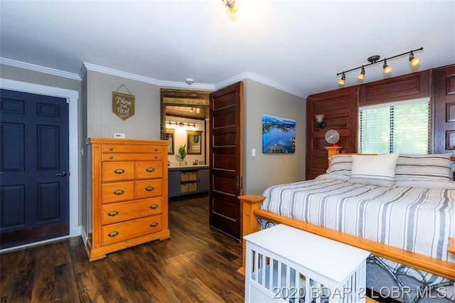 bedroom featuring dark hardwood / wood-style flooring, crown molding, and rail lighting