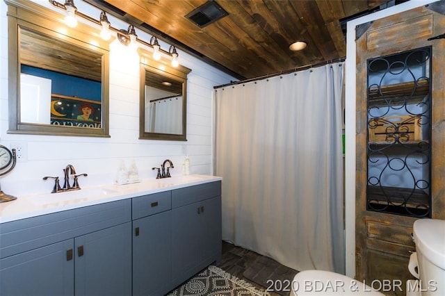 bathroom with vanity with extensive cabinet space, toilet, hardwood / wood-style floors, and wooden ceiling