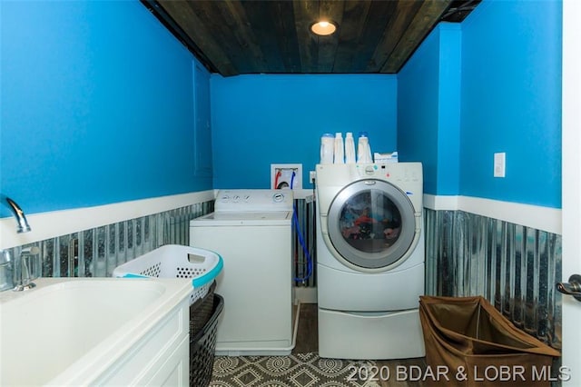 laundry area with separate washer and dryer, wood ceiling, and light tile flooring