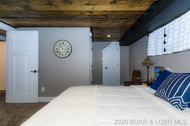 bedroom with dark carpet and wooden ceiling