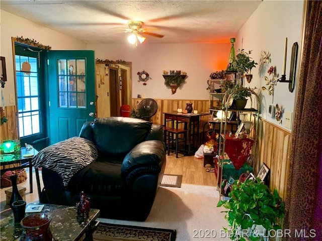 living room with light hardwood / wood-style flooring and ceiling fan