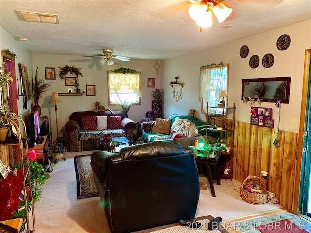 living room featuring plenty of natural light, a textured ceiling, ceiling fan, and light colored carpet