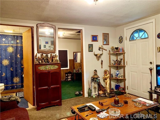 carpeted entrance foyer with a textured ceiling