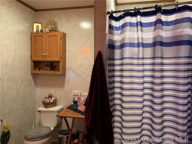 bathroom featuring crown molding and toilet