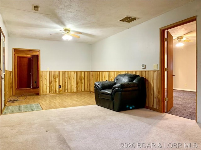 sitting room with light colored carpet and ceiling fan