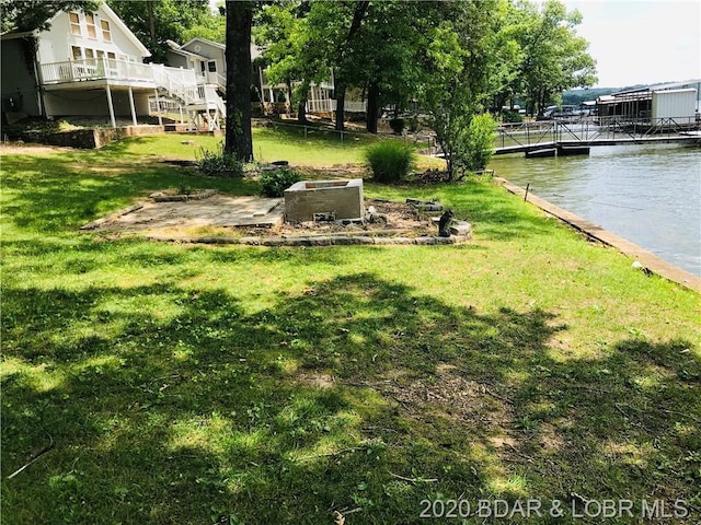 view of yard featuring a boat dock and a water view