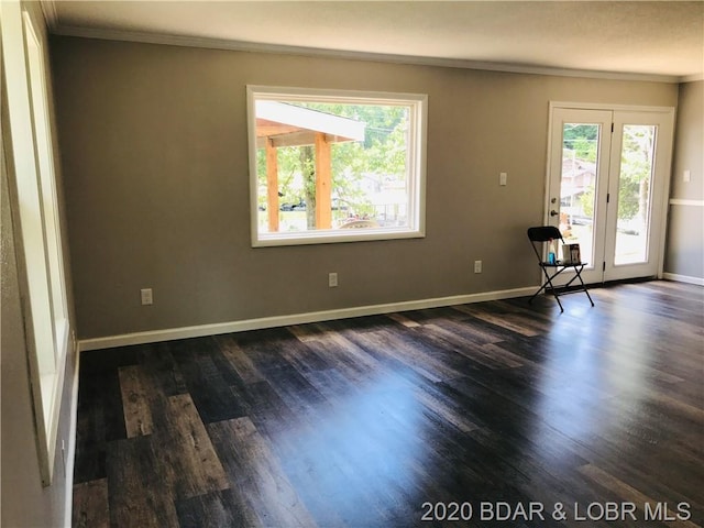 unfurnished room featuring dark wood-type flooring and ornamental molding