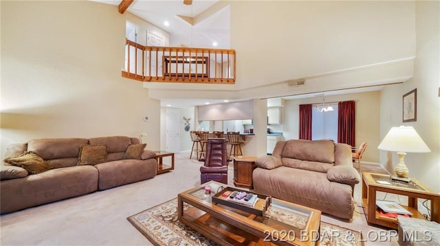 living room featuring light colored carpet and a towering ceiling