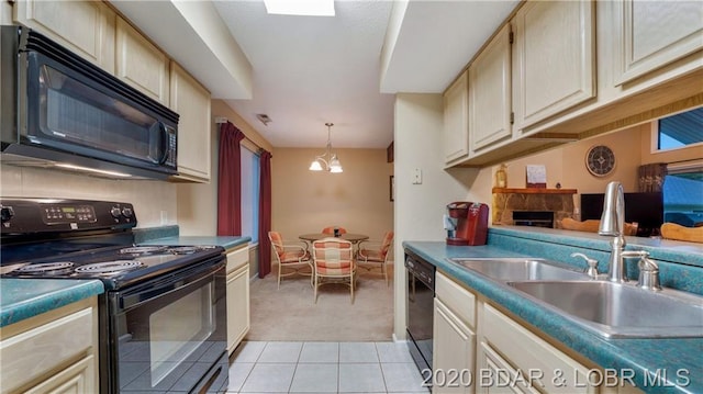 kitchen featuring sink, hanging light fixtures, light tile flooring, black appliances, and cream cabinets