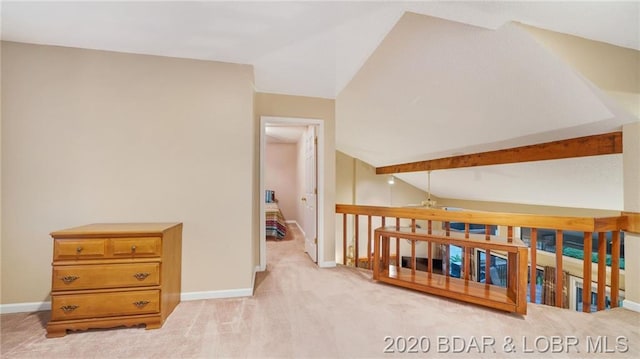 interior space featuring ceiling fan, light colored carpet, and vaulted ceiling