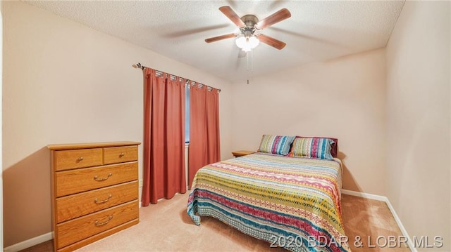 carpeted bedroom with a textured ceiling and ceiling fan