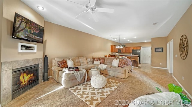 carpeted living room with a fireplace and ceiling fan