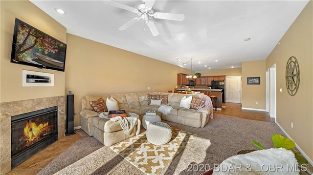 carpeted living room featuring ceiling fan with notable chandelier