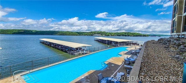 dock area featuring a patio area, a community pool, and a water view