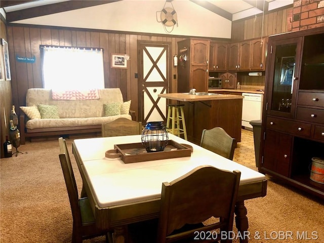 dining room with light carpet, lofted ceiling, and brick wall