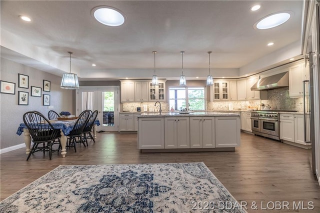 kitchen featuring pendant lighting, a wealth of natural light, and range with two ovens