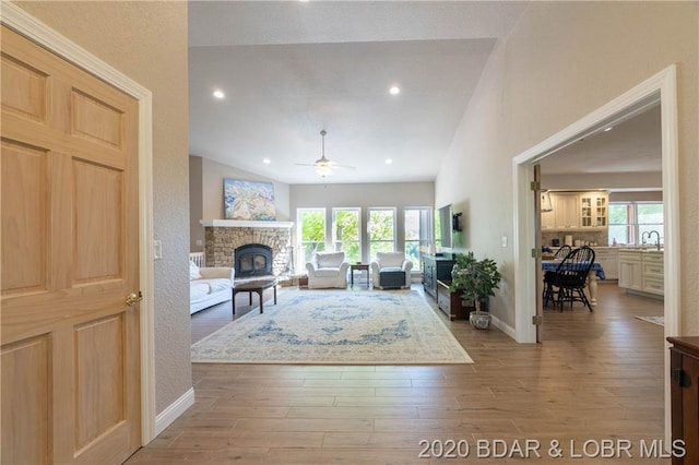 living room with plenty of natural light, lofted ceiling, light hardwood / wood-style floors, and ceiling fan