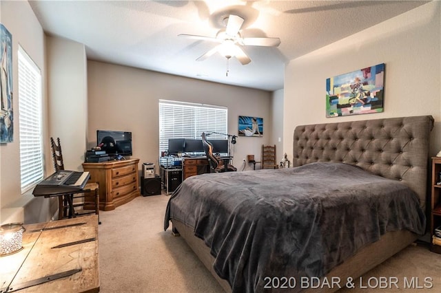 carpeted bedroom with multiple windows, ceiling fan, and a textured ceiling