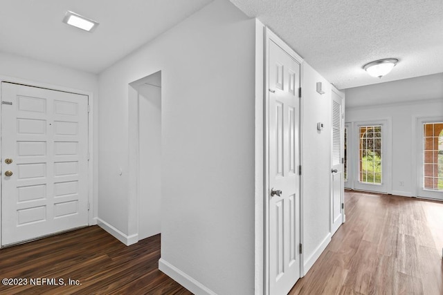 hallway featuring a textured ceiling and dark hardwood / wood-style floors