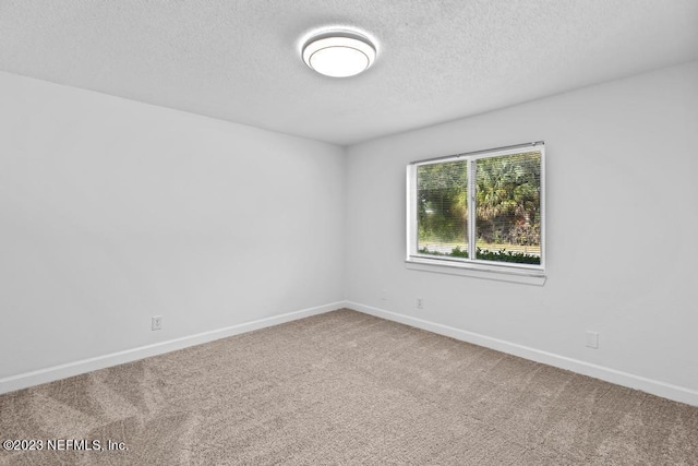 spare room with a textured ceiling and carpet